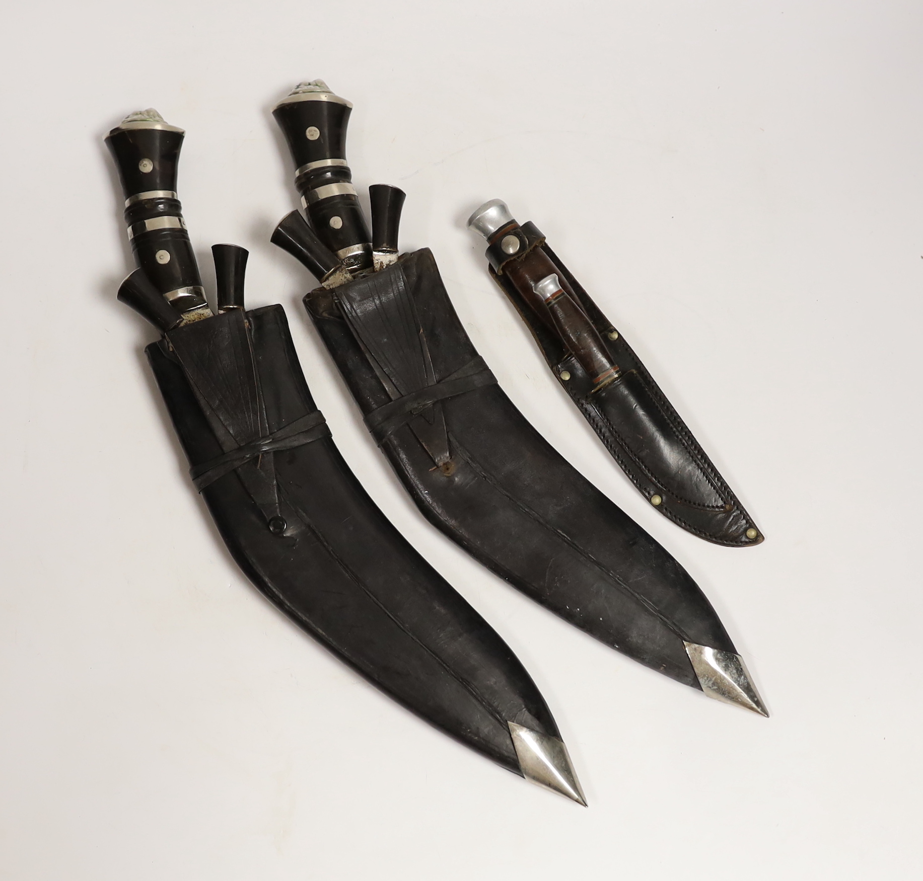 Two large kukris and a smaller similar kukri